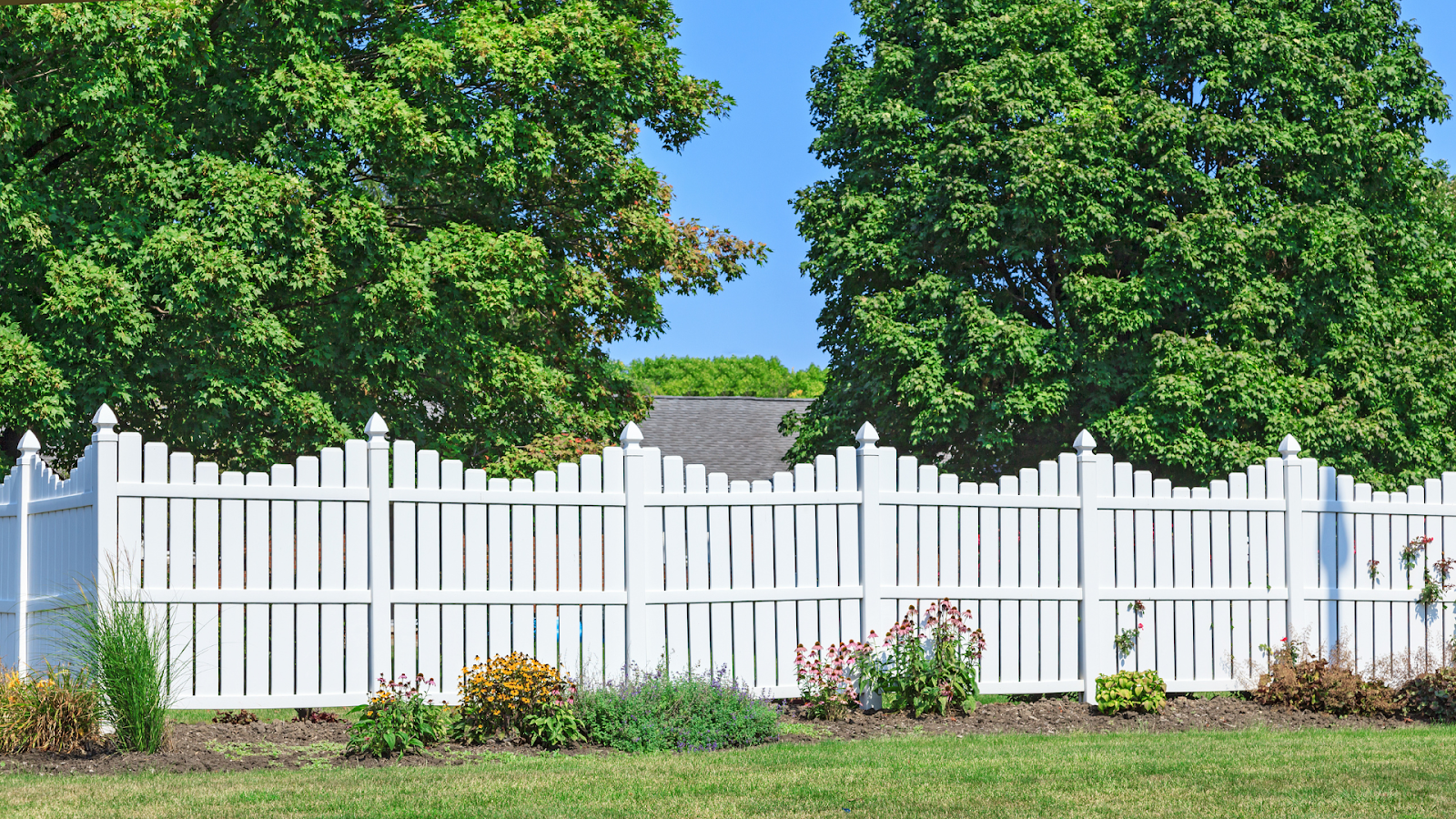 White vinyl fence installed in front of an old property