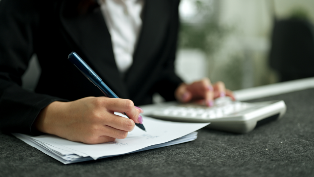 A tax professional reviewing documents and computing figures on a calculator for a property assessment appeal