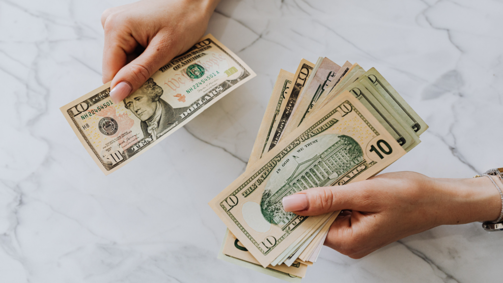 Person separating cash to direct extra payments toward mortgage principal