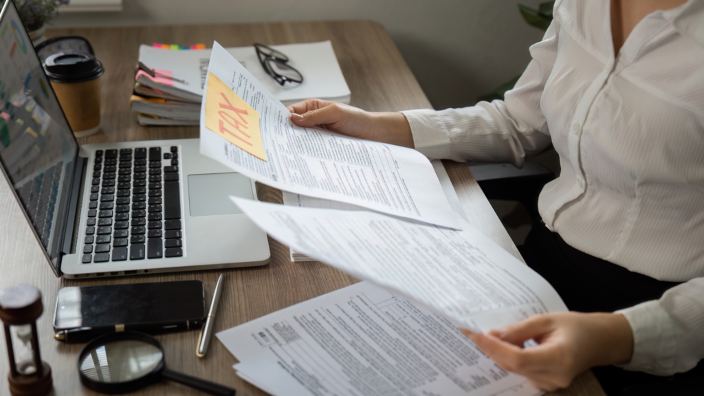 Taxpayer organizing multiple tax forms to correctly report property taxes
